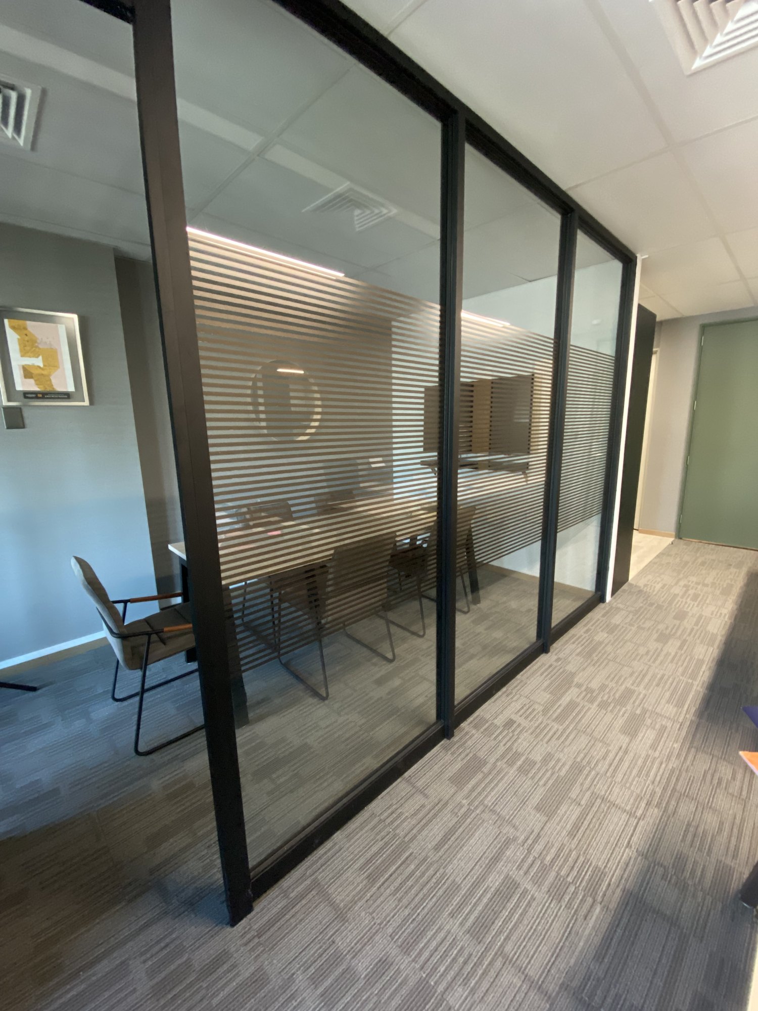 División de vidrio y acceso a una sala de reunión de oficina
